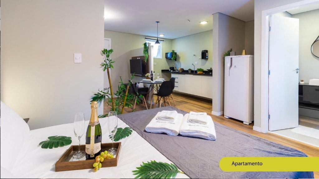 a kitchen and a living room with a white refrigerator at Estúdios Completos no Gonzaga com AC, Canal 3, Vila Belmiro, Unifesp in Santos
