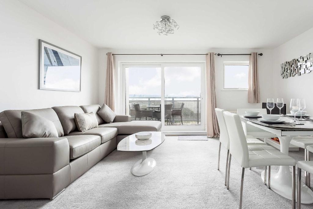 a living room with a couch and a table at Beach Point - Stunning Harbour Views from Balcony in Poole