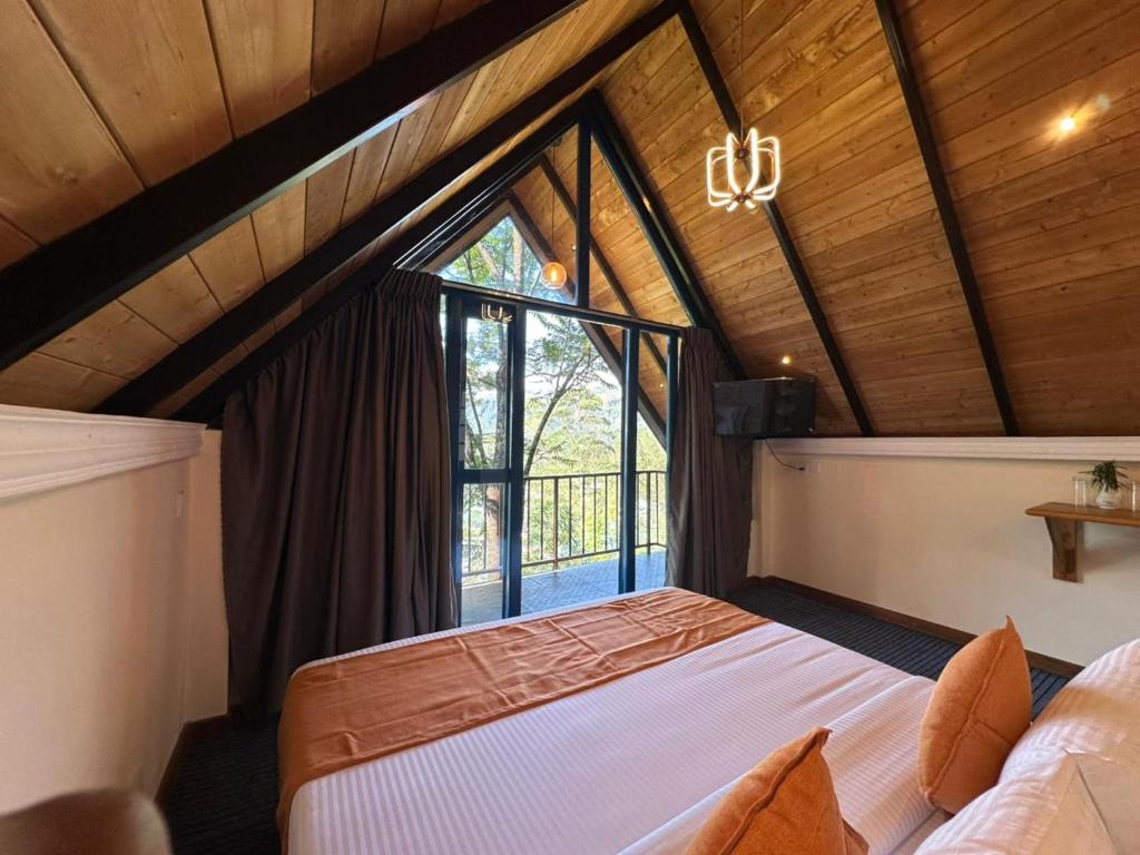 a bedroom with a bed and a large window at Bluefield Cabana in Ramboda