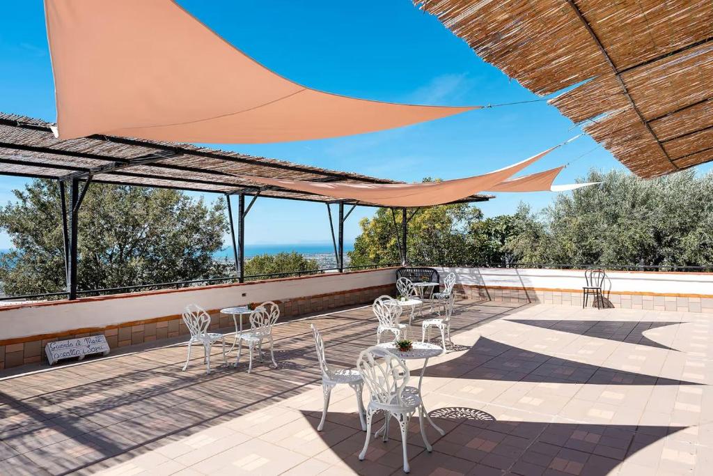 a patio with tables and chairs on a roof at La Fiesta House in Capaccio-Paestum