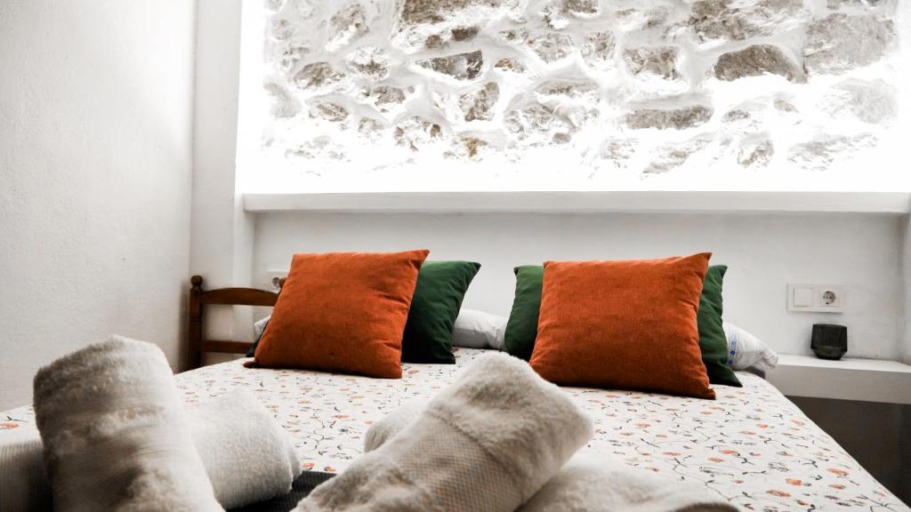 a bedroom with a bed with pillows on it at Casa Rural Pilón Azul in Belerdas