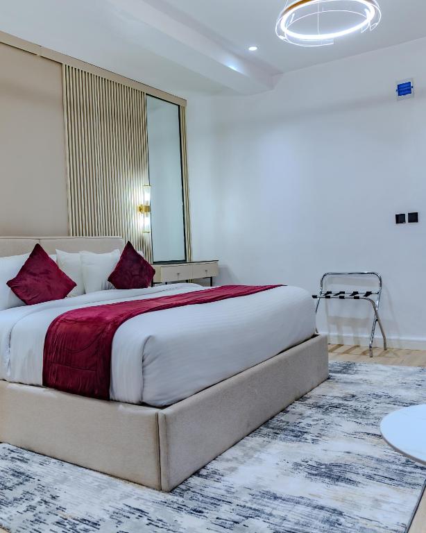 a bedroom with a large bed with a red blanket at Atlantis Hotel Lagos in Lagos