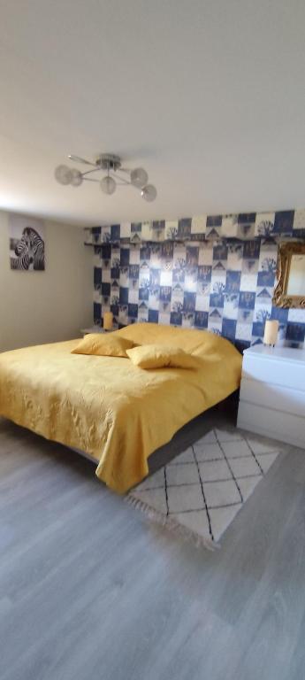 a bedroom with a bed with a yellow comforter at Chez Marianne in Hotton