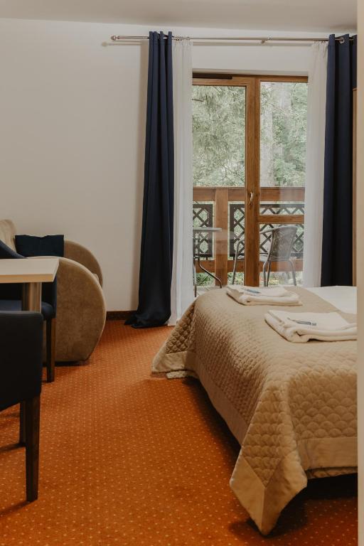 a bedroom with a bed and a window at Holiday Family Pod Świerkami centrum miasta! in Szklarska Poręba