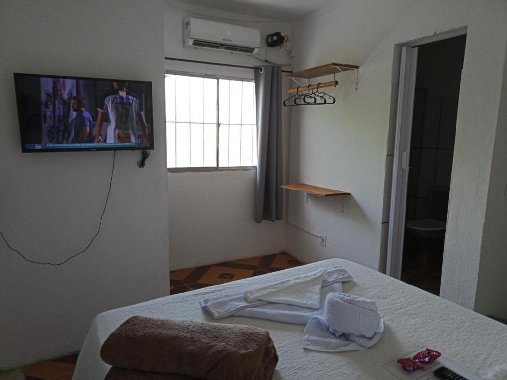 a room with a bed and a tv on the wall at Prédio AZUL in Itacaré