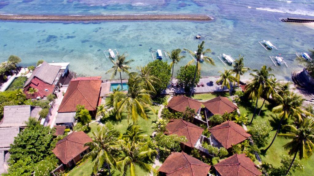 einen Luftblick auf ein Resort mit Palmen und Wasser in der Unterkunft D'Tunjung Resort & Spa in Candidasa