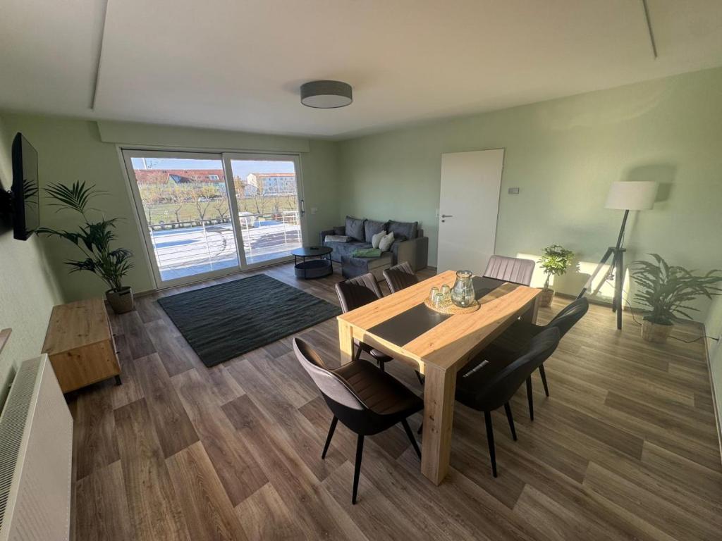 a living room with a wooden table and chairs at Wohnung bei den Drei Gleichen #S in Wandersleben