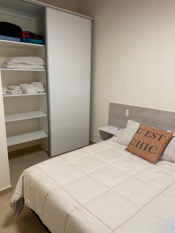 a bedroom with a bed and an open closet at OLÍMPICO in Concepción del Uruguay