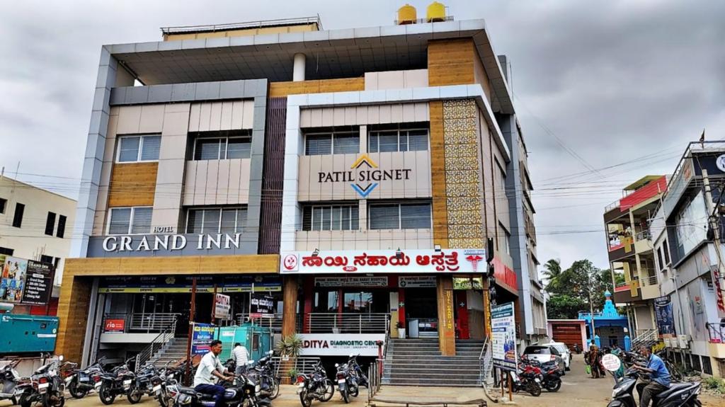 a building with motorcycles parked in front of it at Hotel Grand Inn Jamkhandi in Jamkhandi