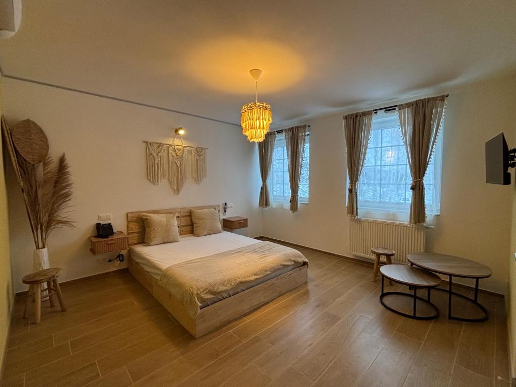 a bedroom with a bed and a table and a chandelier at Le Bovary Hotel Riad in Héron
