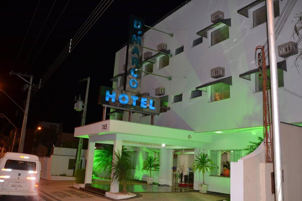 un hotel con un letrero de neón delante de él en Dmarco Hotel, en Paraguaçu Paulista