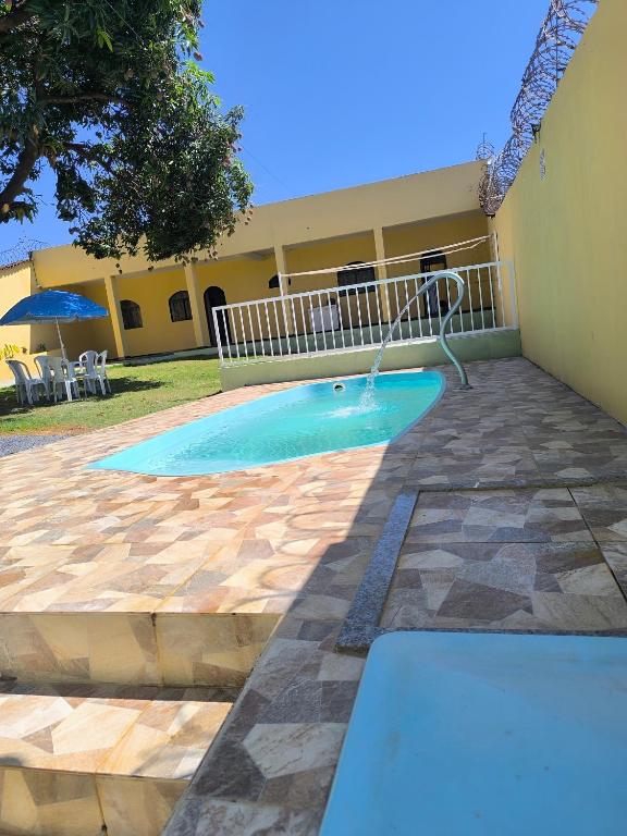 a swimming pool in front of a building at Casa Alegria até 9 pessoas, Piscina, Churrasqueira, Empresas e Grupos in Montes Claros