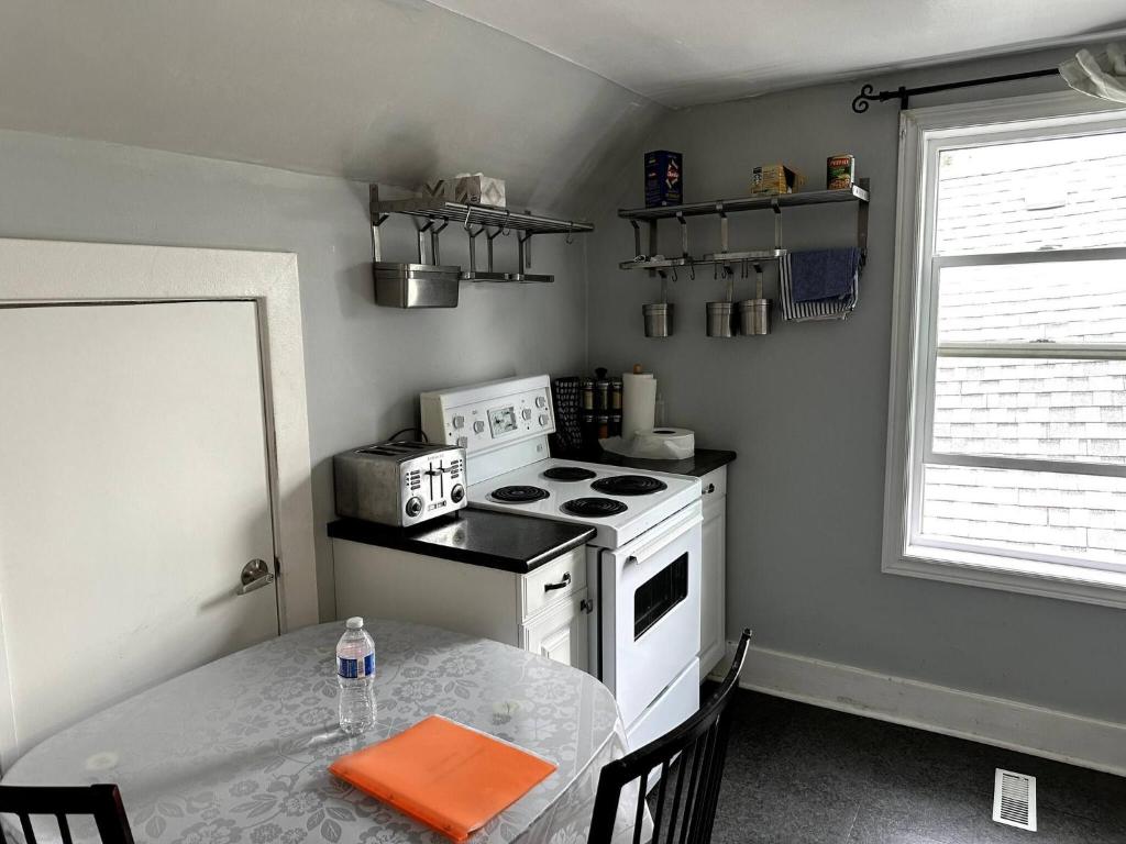 a kitchen with a white stove and a table and a window at Cozy Duplex 2nd floor suite in Winnipeg