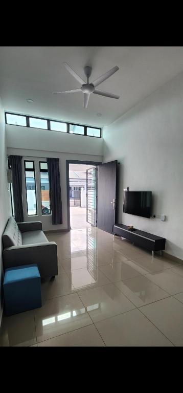 a living room with a couch and a flat screen tv at Spacious 4 bedroom homestay in Mersing