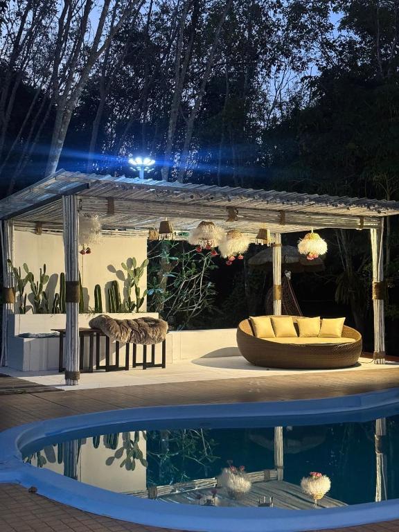 a pergola and a swimming pool at night at Phumaihom Resort in Hat Yai