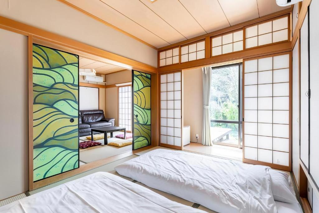 a japanese bedroom with a bed and a window at Blodge Lodge in Wazuka