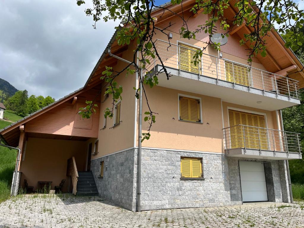 a house with a balcony on the side of it at Pr Fajfarju in Spodnja Sorica