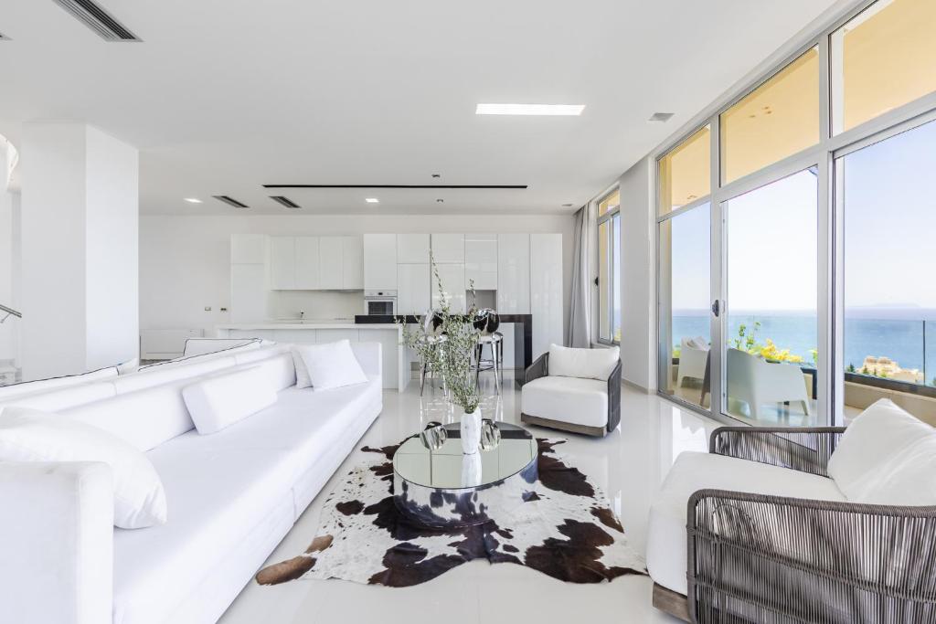 a living room with a white couch and a table at Villa Belle Azure by PikHost in Dhërmi