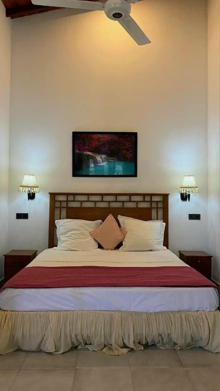 a bedroom with a large bed with a ceiling fan at Villa Mistora in Kandy