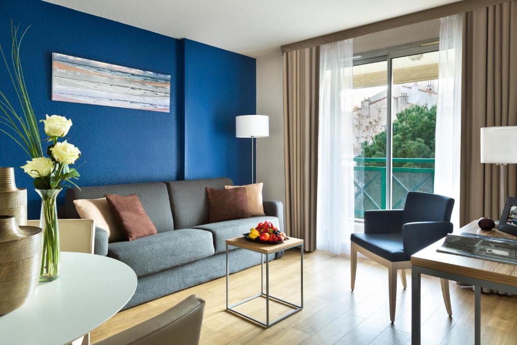 a living room with a couch and a table at Citadines Prado Chanot Marseille in Marseille