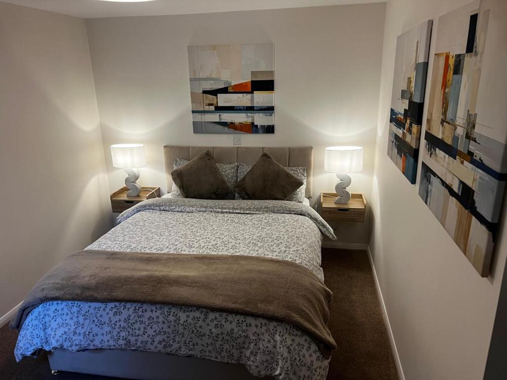 ein Schlafzimmer mit einem Bett und zwei Lampen auf zwei Tischen in der Unterkunft Witz End in Corsham
