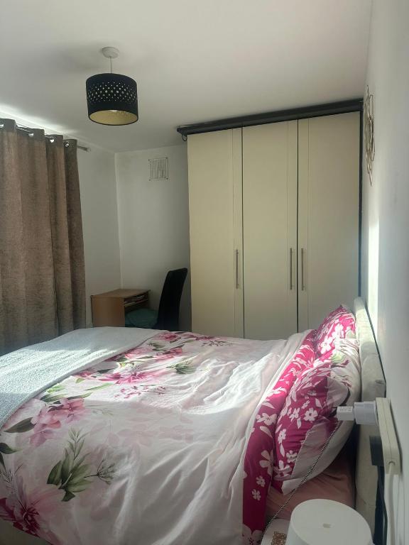 a bedroom with a bed with pink sheets and white cabinets at Cozy Room , prime location in Dublin
