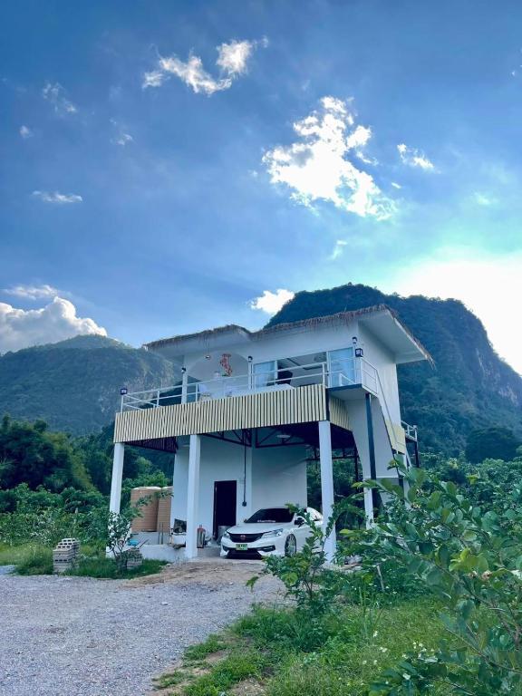 una casa con un'auto parcheggiata davanti di บ้านสวนจมูกโต a Ban Pha Mi