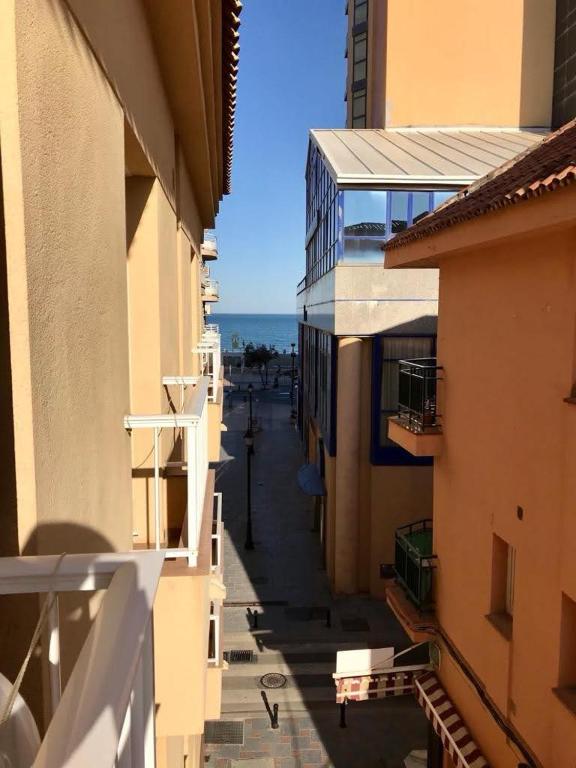 an alley between two buildings with the ocean in the background at Jeribel PlayA1 in Fuengirola