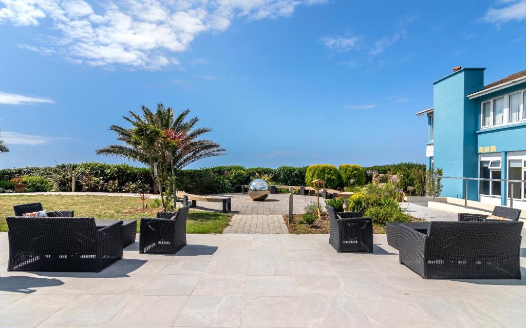 a patio with chairs in front of a building at Maison des Landes - Accessible Hotel in St. Ouen's