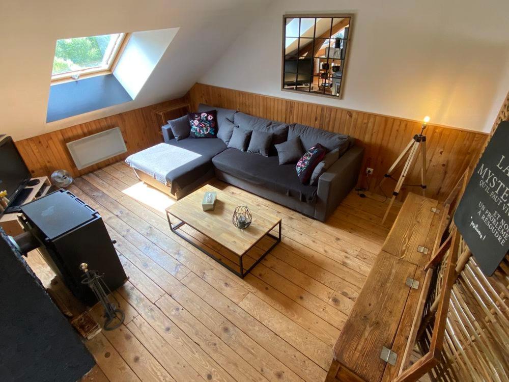 a living room with a couch and a table at Loft des Cimes - Evasion en montagne avec local vélo privé in Cornimont