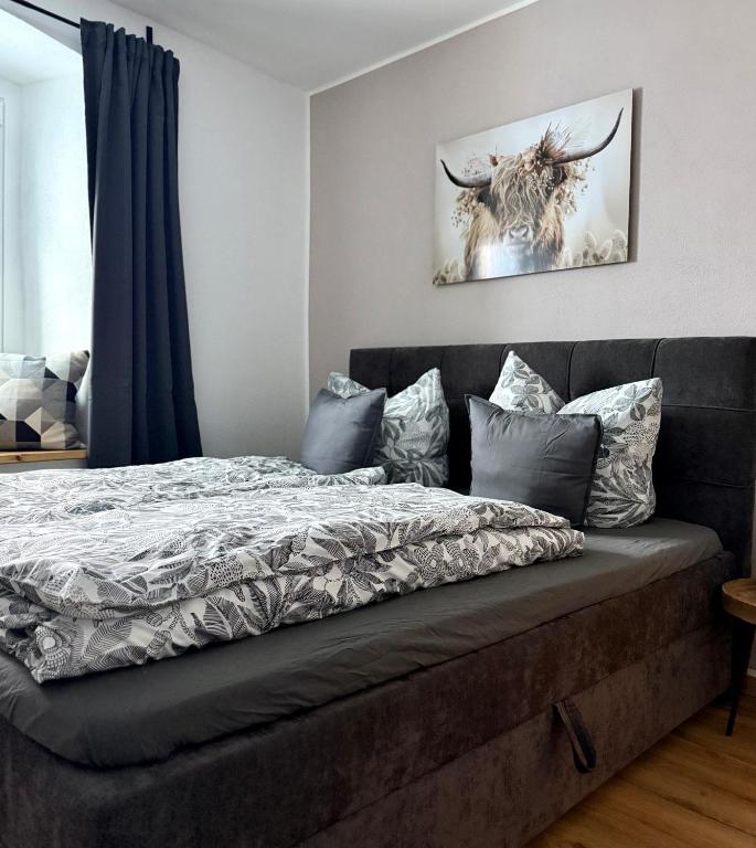 a bed in a bedroom with a picture of a deer at Wohnzeit by Zirwick Apartment in Windischeschenbach