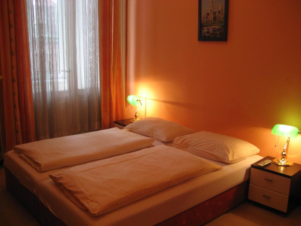 Un pat sau paturi într-o cameră la Pension Schottentor