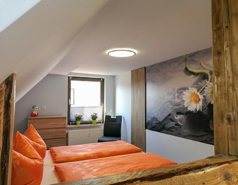 a attic bedroom with two beds and a desk at Ferienwohnung Dreams in Hasselfelde