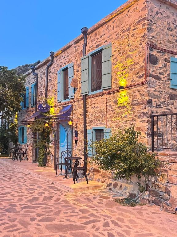 a brick building with benches in front of it at FİNTOZ BUTİKA New in Karaburun