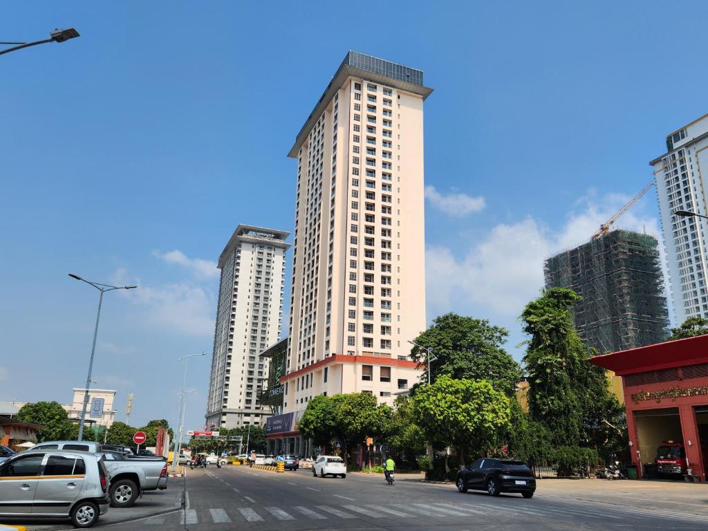 a city street with cars parked in front of tall buildings at A One Oasis River View Hotel in Phnom Penh