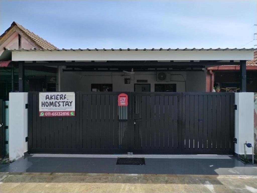 a black gate with a sign in front of a house at Akiera Homestay #MELAYU ONLY in Pelabuhan Kelang