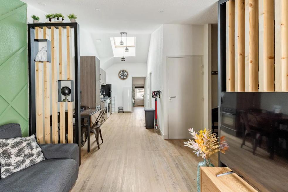 a living room with a couch and a dining room at le karibu appartement confort tout équipé in Lagnieu