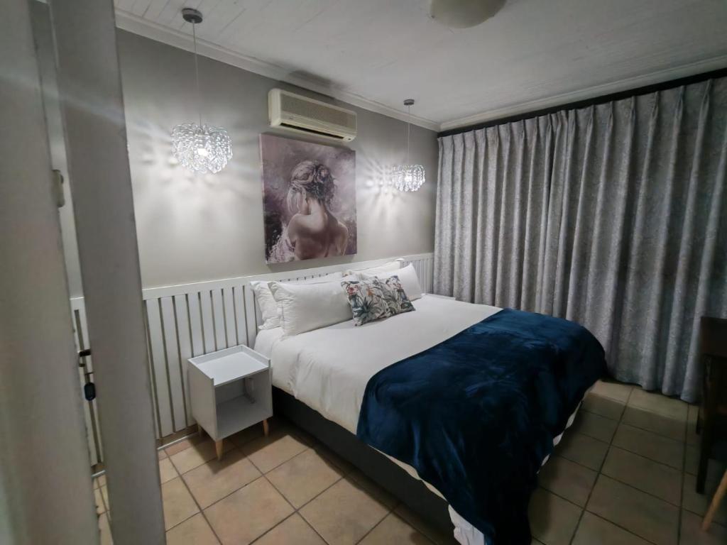 a bedroom with a bed with a blue blanket at Flat 1 in Kimberley
