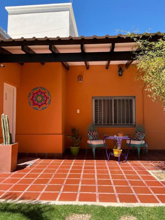 an orange house with a table and chairs on a patio at Cepas del Valle - cabañas y suites in Chilecito