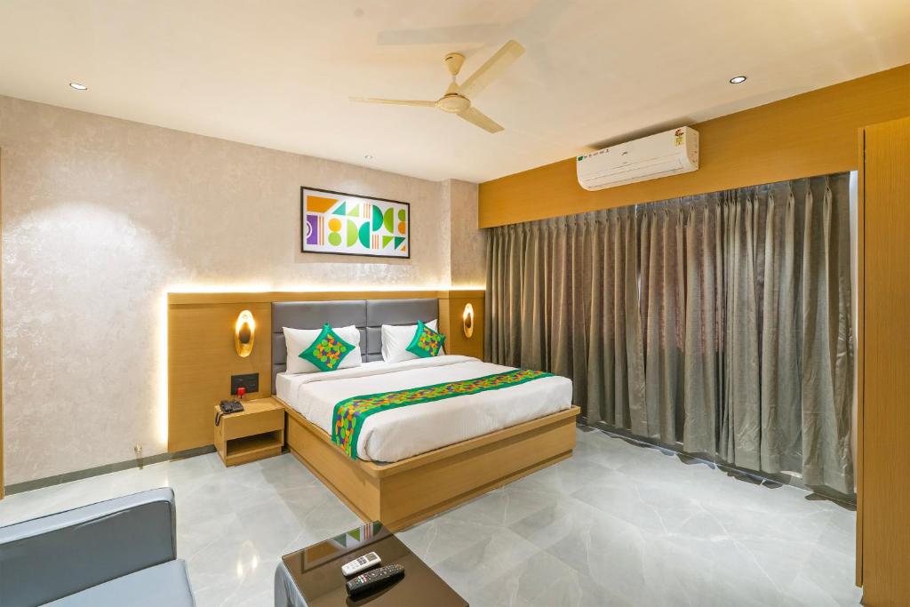 a bedroom with a large bed and a window at Treebo Sairadha in Pune