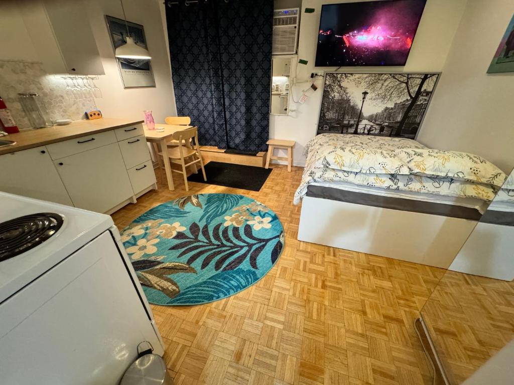 a small room with a bed and a kitchen with a rug at Montreal Hideaway in a Residential area in Montreal