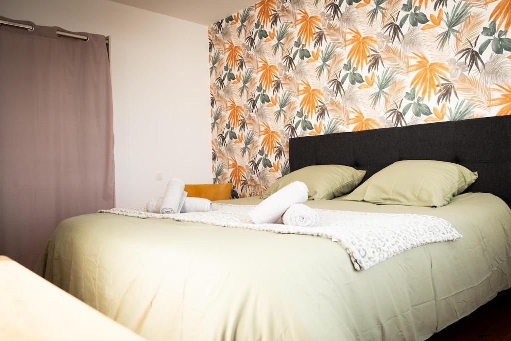 a bedroom with two beds and a floral wall at Have a Cosy, Élégance in Grand-Fort-Philippe