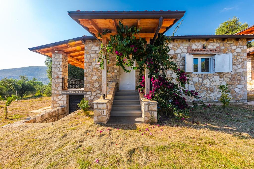 a stone house with a staircase leading to a door at Siar The Small Villa by PikHost in Borsh