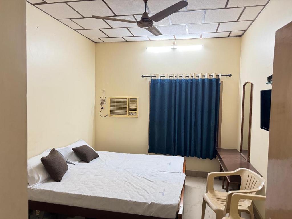 a bedroom with a bed and a ceiling fan at SriI Kanya Lodge in Mandapeta