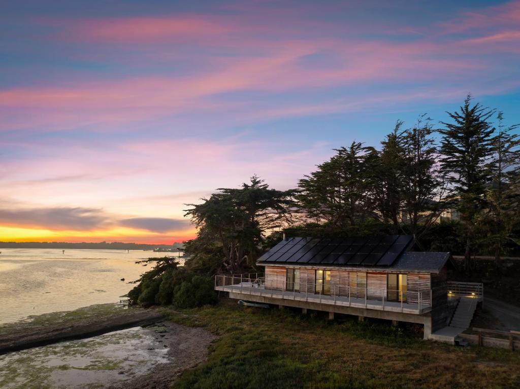 a house on the beach with a sunset in the background at Bodega Bay - Ocean View, Fireplace & BBQ in Bodega Bay