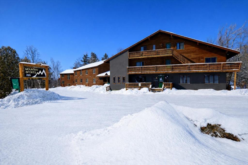 a snow covered parking lot in front of a lodge at Mountain Sports Inn in Killington