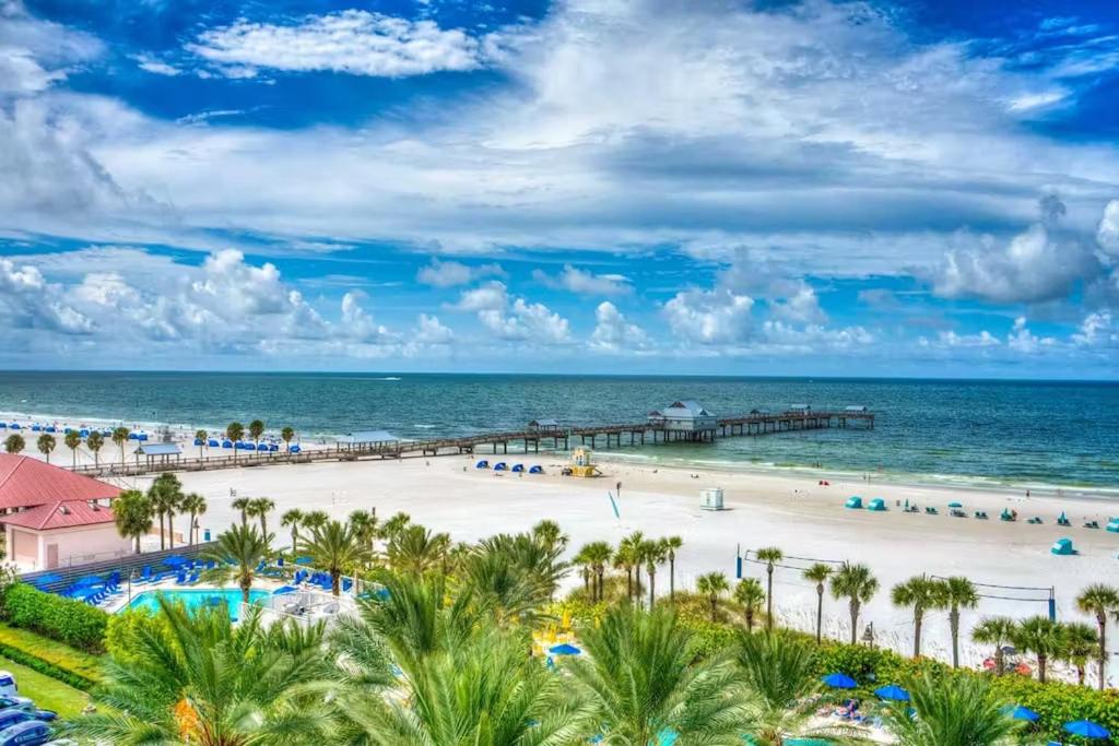 a beach at a resort with palm trees and the ocean at Clearwater Beach Pelican 2 in Clearwater Beach