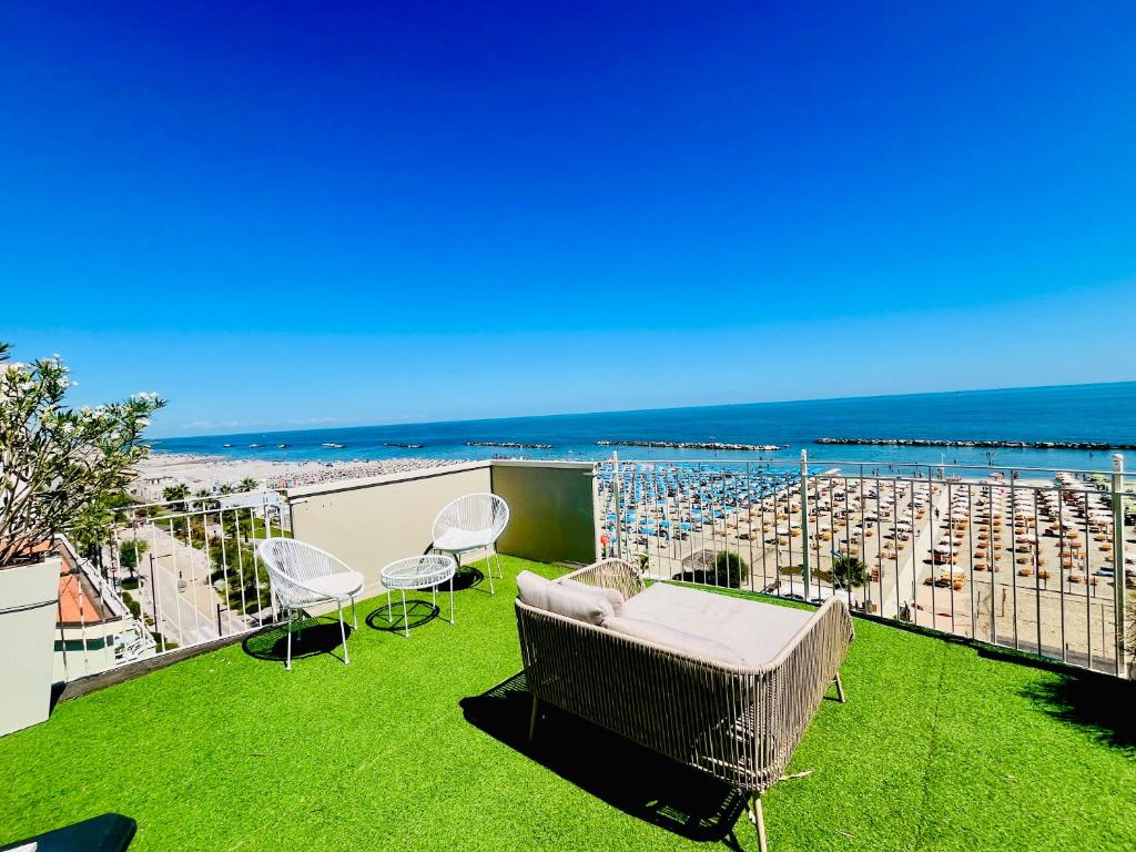 a balcony with a table and chairs and a beach at Residence Frontemare in Rimini