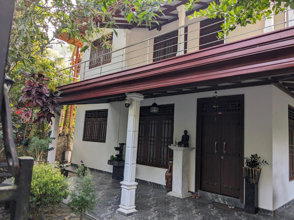 a house with two doors and a porch at Villa 505 Induruwa in Induruwa