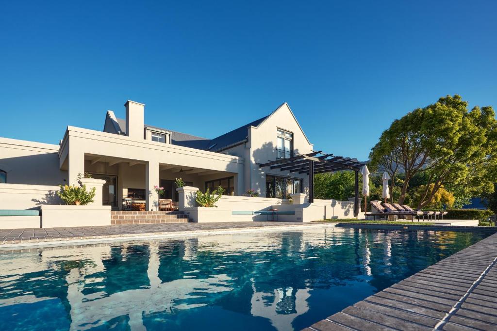 a house with a swimming pool in front of a house at The Manor House at Colmant in Franschhoek